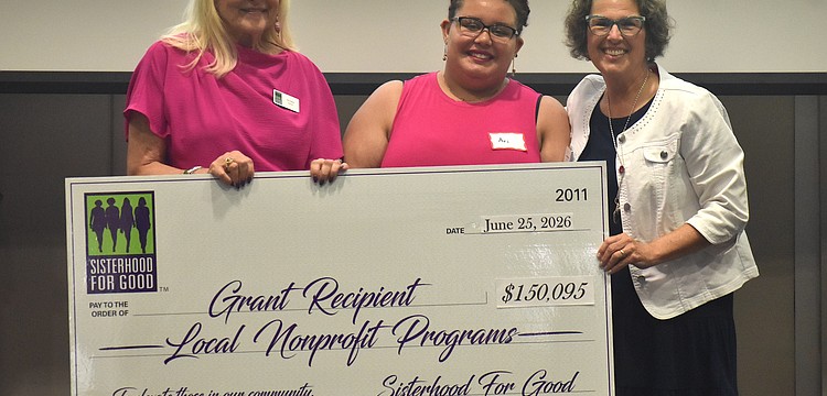 Sisterhood for Good's Glo Reber presents Harbor58's Ari Gibbons and Annie Wilson a grant for $7,500 to go towards a mentoring program for foster kids.
