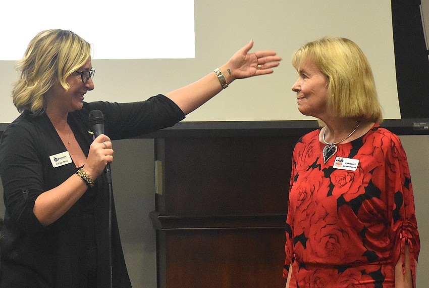 Sisterhood for Good's Allison Imre Perkowski presents a $2,500 grant for nonprofit Jackson's Gift to Christine Carruthers, a member of the Jackson's Gift board of directors.