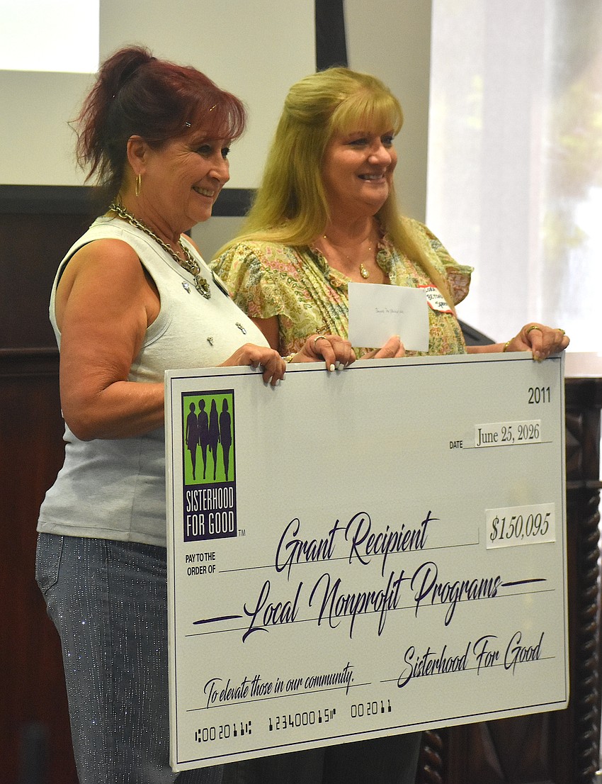 Sisterhood for Good's Darci Jacob presents Lora Carpenter, president and CEO of Beyond the Spectrum, a grant for $2,250 to help children with disabilities attend summer camp.