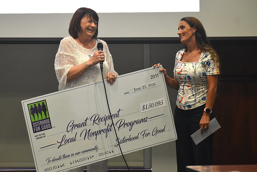 Sisterhood for Good's Sheryl Cobb presents Celia Kane, program director of Catholic Charities Diocese of Venice, a grant of $3,000 that will provide 20 mental health sessions to members of Our Mother's House, a two-year transitional living program.