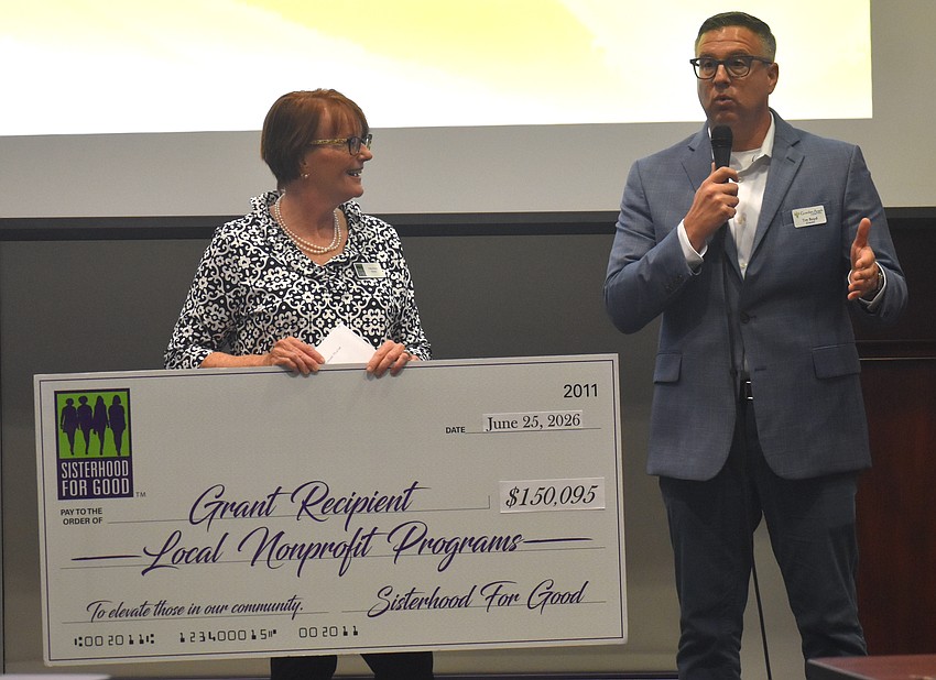 Sisterhood for Good's Patty Kane presents a $5,000 grant to Tim Boyd, director of Guardian Angels of Southwest Florida. The grant will help cover the cost of food, household items and more for foster families.