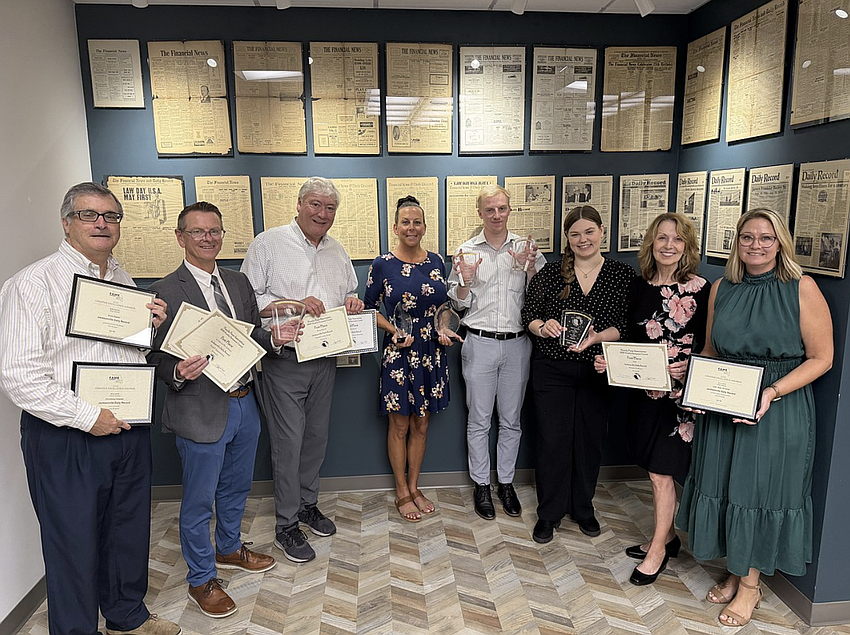 Angela Campbell, right, publisher of the Jacksonville Daily Record, joins staff members displaying awards won by the publication at the 2026 Florida Media Conference. From left are Stephen Reynolds, multimedia advertising consultant; Ric Anderson, editor; Dan Macdonald, staff writer; Codi Rinehart, graphic designer; Joe Lister, staff writer; Kaili Cochran, news designer; and Karen Brune Mathis, editor at large; and Campbell.