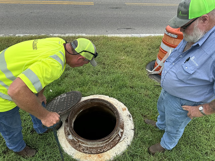 Sarasota County Stormwater Department workers inspect an underground pipe. Sarasota County Stormwater Department workers inspect an underground pipe.