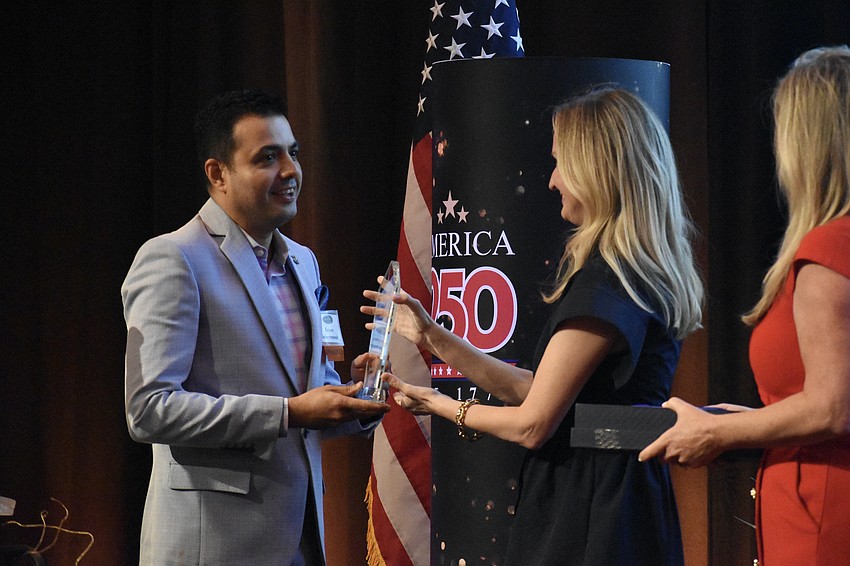 Bayan Sabermanesh, director of operations at The Ritz-Carlton, accepts the Hospitality Business of the Year award from Erin Duggan, president and CEO of Visit Sarasota County.