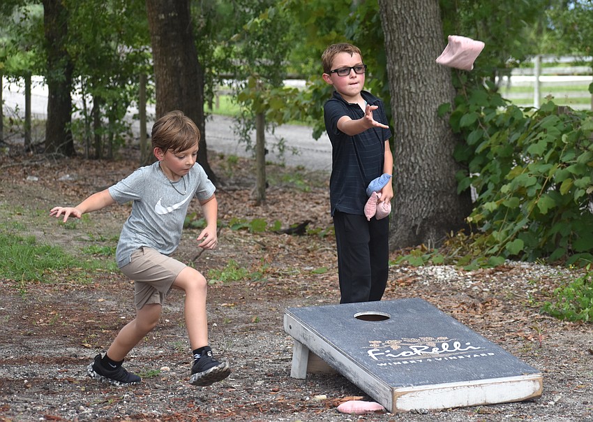 Sarasota's Logan Moran and Nicholas Lane, both 9 years old, play cornhole at the Red, White and Blueberry Celebration at Fiorelli Winery.
