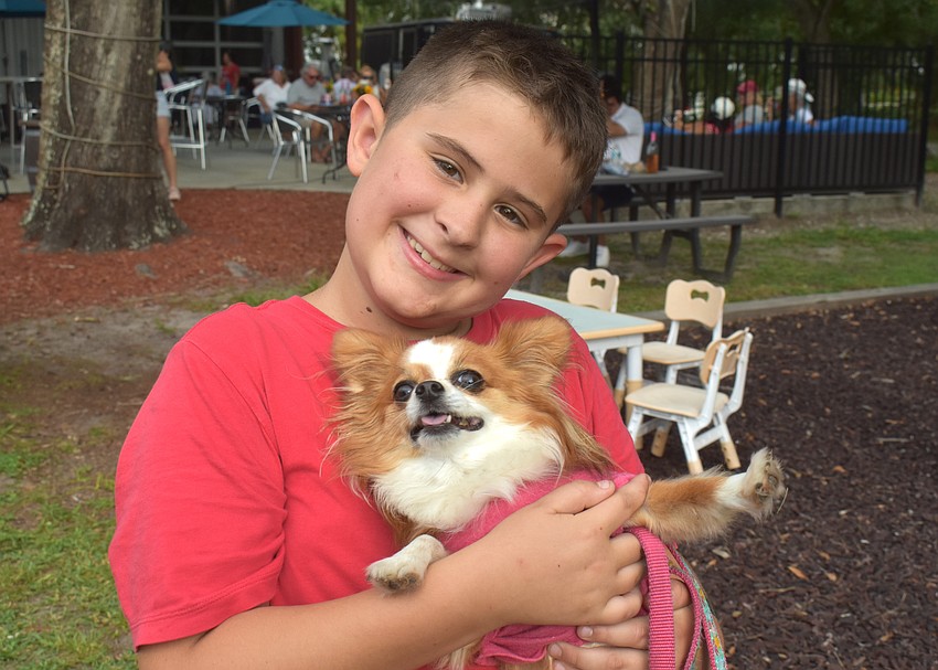 Sarasota's Sage Taylor, 8, explores the Red, White and Blueberry Celebration at Fiorelli Winery with dog, Piper.