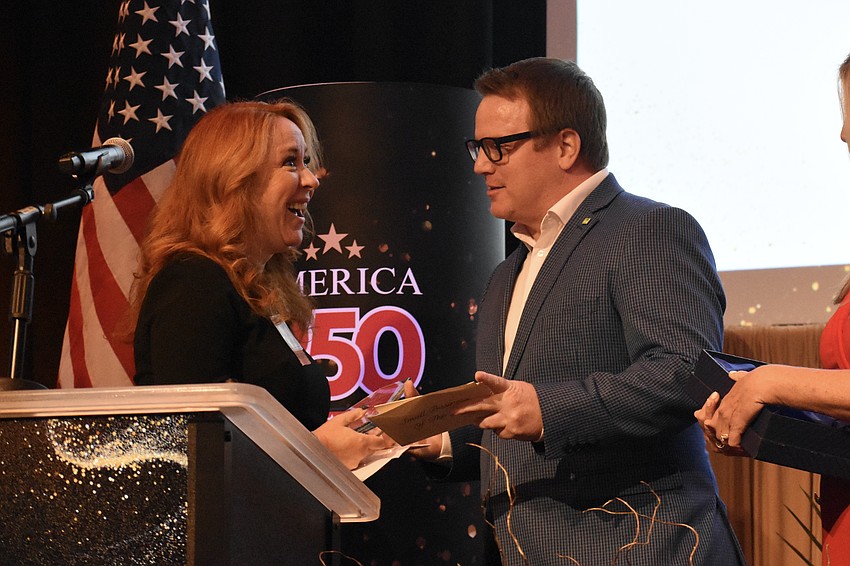 Jill Athridge of Stage Door Studios accepts the Small Business of the Year award from Josh Talkington, director of communications with the Sarasota-Bradenton International Airport.