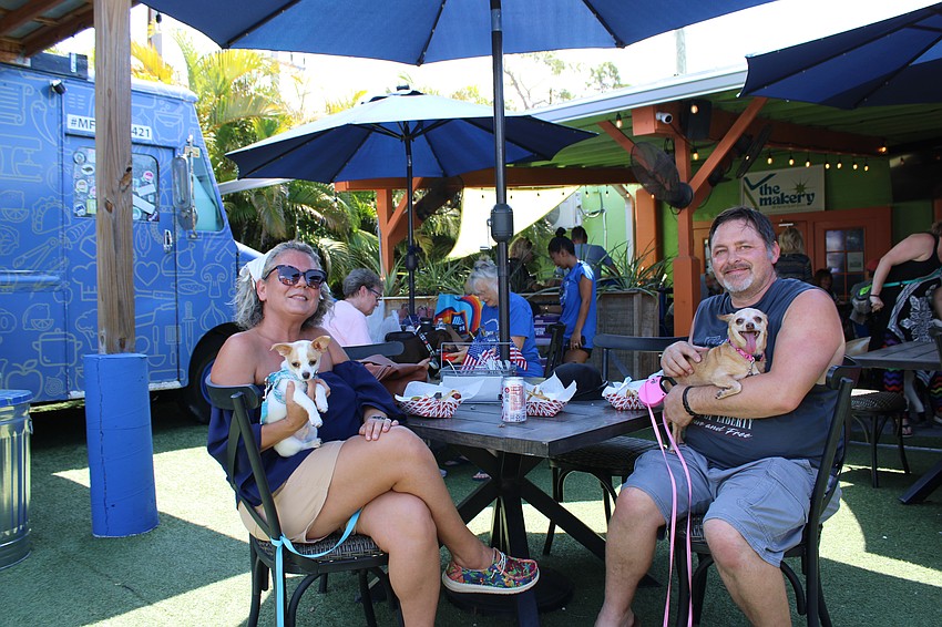 Desiree Laventure, holding Tito and Jessie Showen holding Tikka, are enjoying the hot dogs from Hamlet's Eatery on their annual Hot Dog Day.