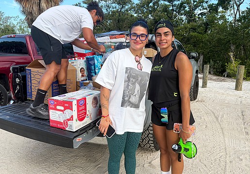 Carla Paola Ventura, organizer of Sunday's aid drive to support Venezuelan earthquake survivors, and Noemi Ottenwalder, founder of the new Latinas Run Club that hosted the drive, load supplies into the truck after the morning run on Lido Key. Ventura said while the devastation is far-reaching, small contributions made by many people amount to a big difference.