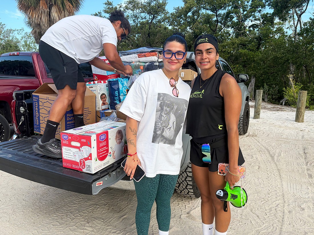 Carla Paola Ventura, organizer of Sunday's aid drive to support Venezuelan earthquake survivors, and Noemi Ottenwalder, founder of the new Latinas Run Club that hosted the drive, load supplies into the truck after the morning run on Lido Key. Ventura said while the devastation is far-reaching, small contributions made by many people amount to a big difference.
