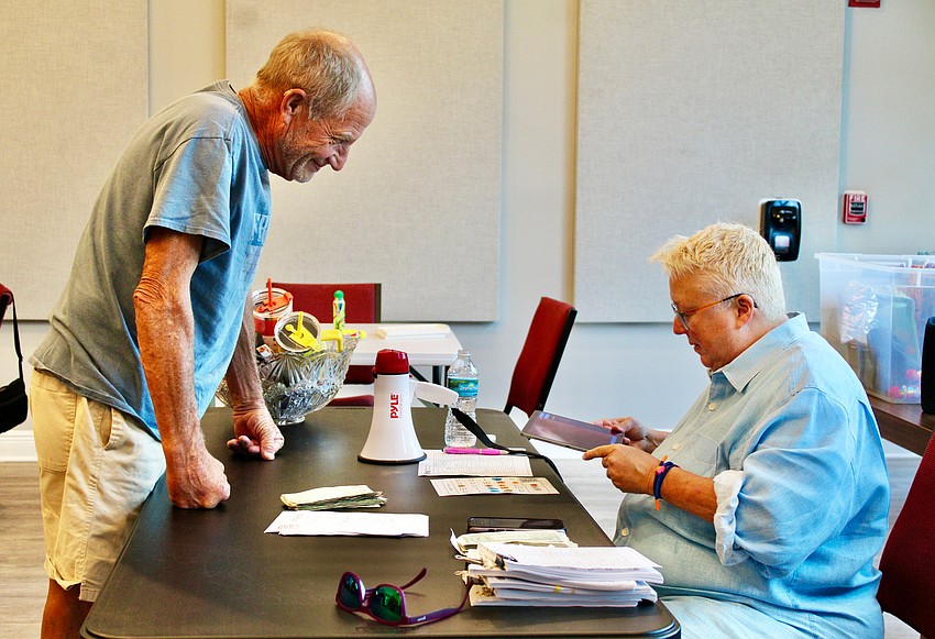 Reneé Fannin checks Gregg Vesta's card after he calls bingo — or rather, singo — at the musical game night. He was the first winner at the new event at The Paradise Center.