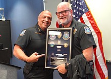 Sarasota Police Chief Rex Troche presents Officer William "Tripp" Schwenk with his framed badge during his June 26 retirement ceremony.