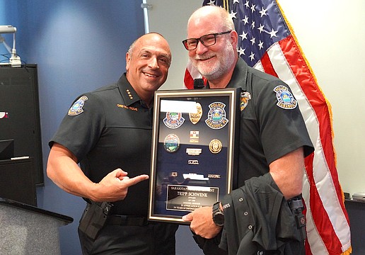 Sarasota Police Chief Rex Troche presents Officer William "Tripp" Schwenk with his framed badge during his June 26 retirement ceremony.