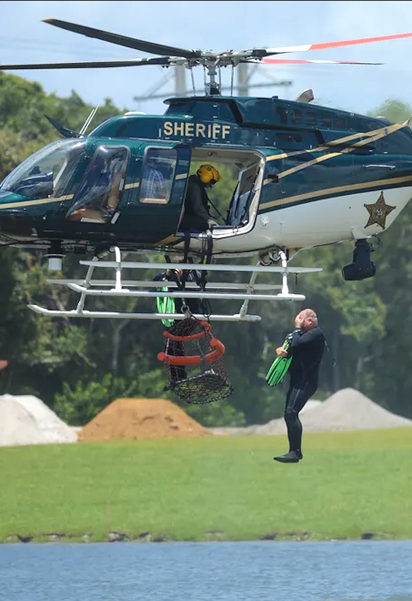 SPD Officer Tripp Schwenk drops into the water from a Sarasota County Sheriff's Office helicopter during a water rescue training exercise. SPD Officer Tripp Schwenk drops into the water from a Sarasota County Sheriff's Office helicopter during a water rescue training exercise.