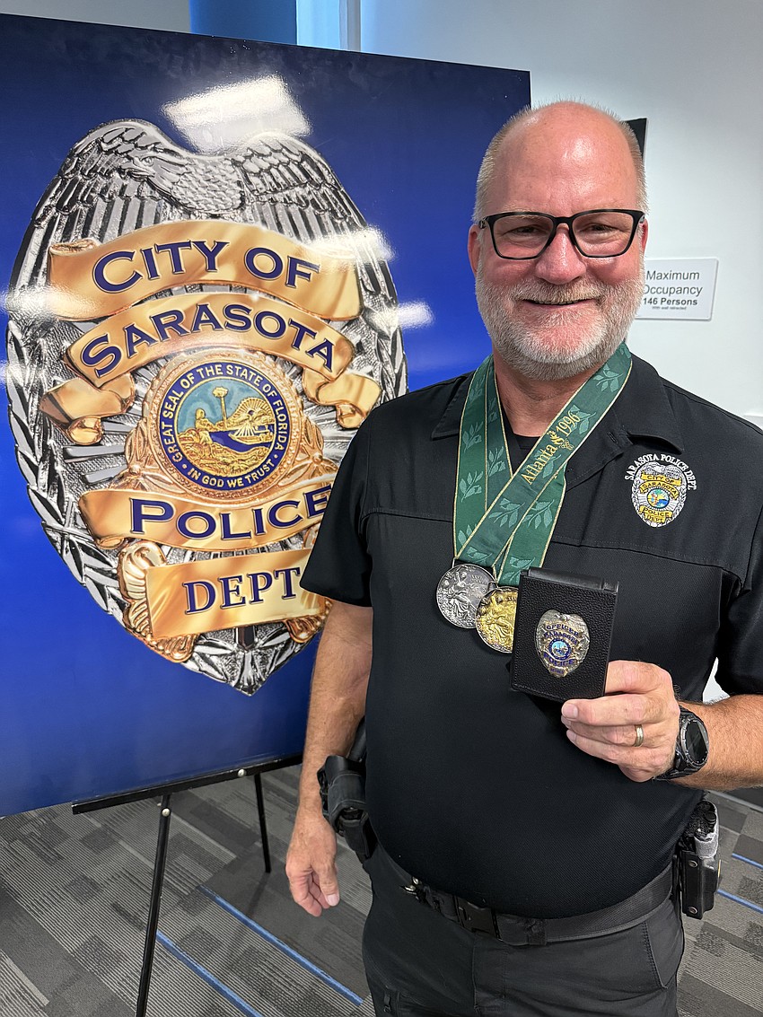 Retired Sarasota Police Officer Tripp Schwenk shows off his two Olympic medals and badge. Retired Sarasota Police Officer Tripp Schwenk shows off his two Olympic medals and badge.