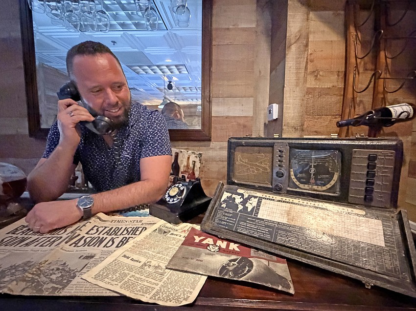 Answering the phone, Austin Arthur can hear General George S. Patton yelling at him. This section of the bar also includes one of the first transatlantic radios.