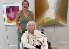 Beth Arthur poses with her granddaughter Sandy Arthur in front of two paintings acquired by Arts Advocates Gallery, "Bryce Canyon" (left) and "Sky Dreams."