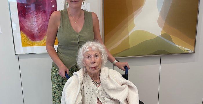Beth Arthur poses with her granddaughter Sandy Arthur in front of two paintings acquired by Arts Advocates Gallery, "Bryce Canyon" (left) and "Sky Dreams."