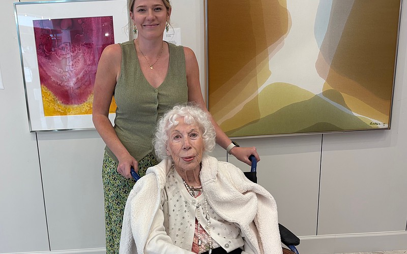 Beth Arthur poses with her granddaughter Sandy Arthur in front of two paintings acquired by Arts Advocates Gallery, "Bryce Canyon" (left) and "Sky Dreams."