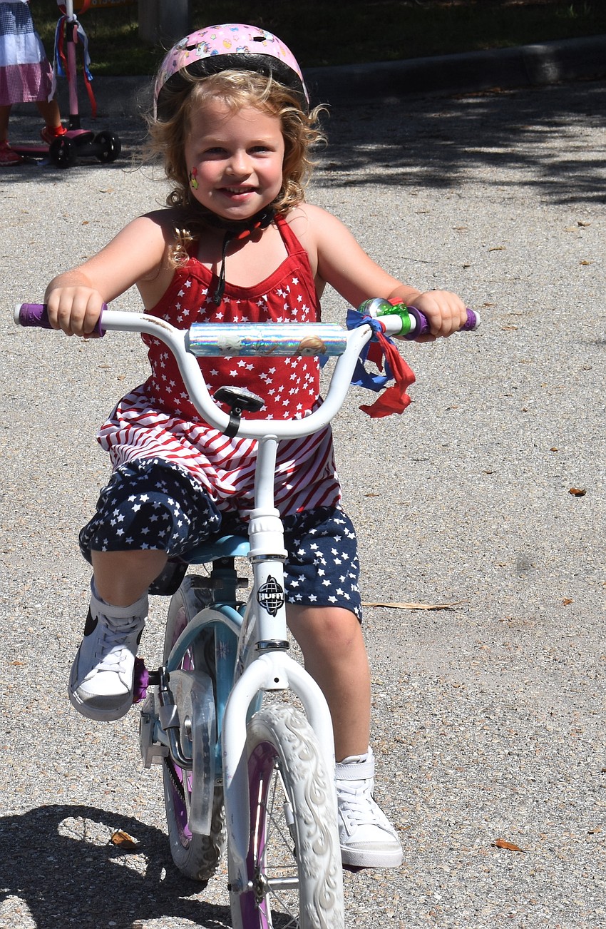 Eva Freniere, 4, was happy to ride her bike, listen to music and eat popsicles during the Kiddie Academy of Lakewood Ranch bike parade.