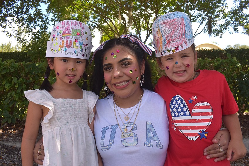 Ariana Do, Assistant Teacher Berenice Giles and Maya Delvalle embrace the holiday with hand-colored hats and stickers on their faces.