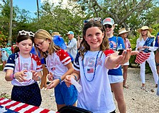 Lucy Clark and Carlin and Ellie Mackintosh, granddaughters of Longboat Key artist May Lou Johnson, help release the first of 250 butterflies at Freedom Fest. The Fourth of July festivities also included a parade, canine costume contest, rededication of Bicentennial Park and family activities.