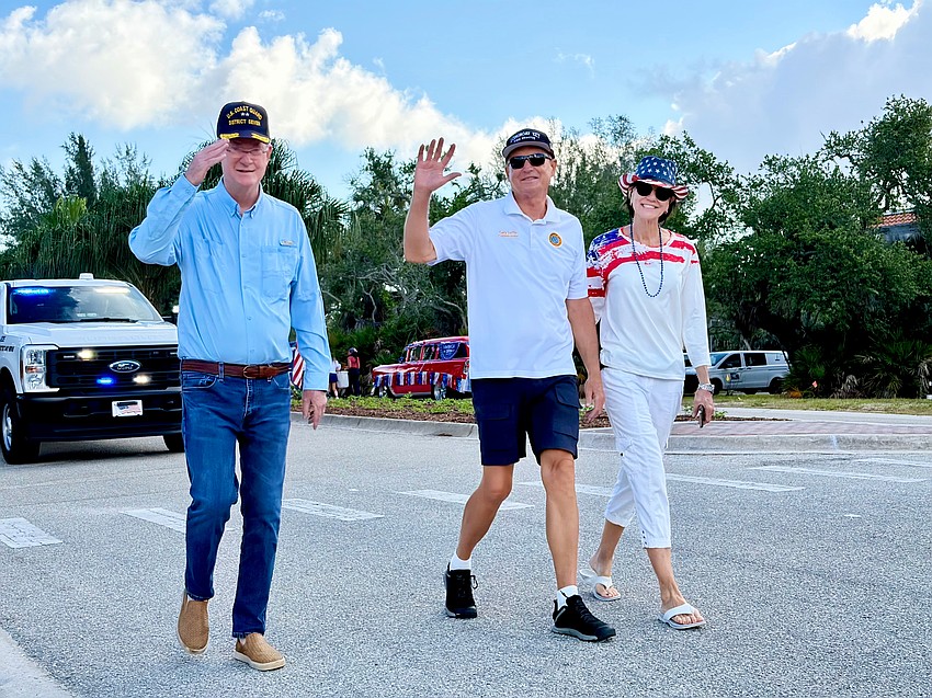 Town of Longboat Key Commissioner Steve Branham salutes while walking in the Freedom Fest parade with Commissioner Gary Coffin and Lynn Armstrong Coffin.