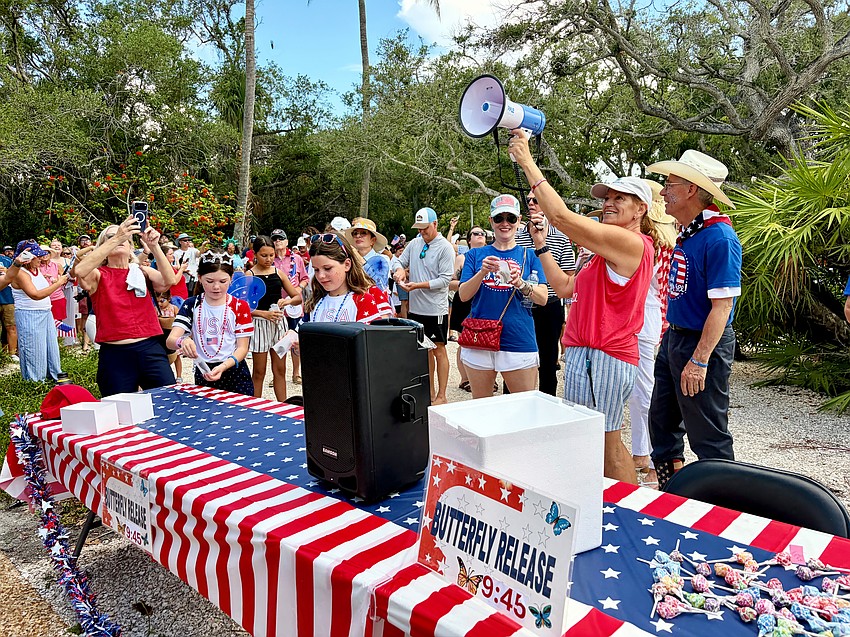 Longboat Key Garden Club President Melanie Dale gives the signal to release all 250 live butterflies at Freedom Fest. The tradition celebrates the memory of Lisa Walsh.
