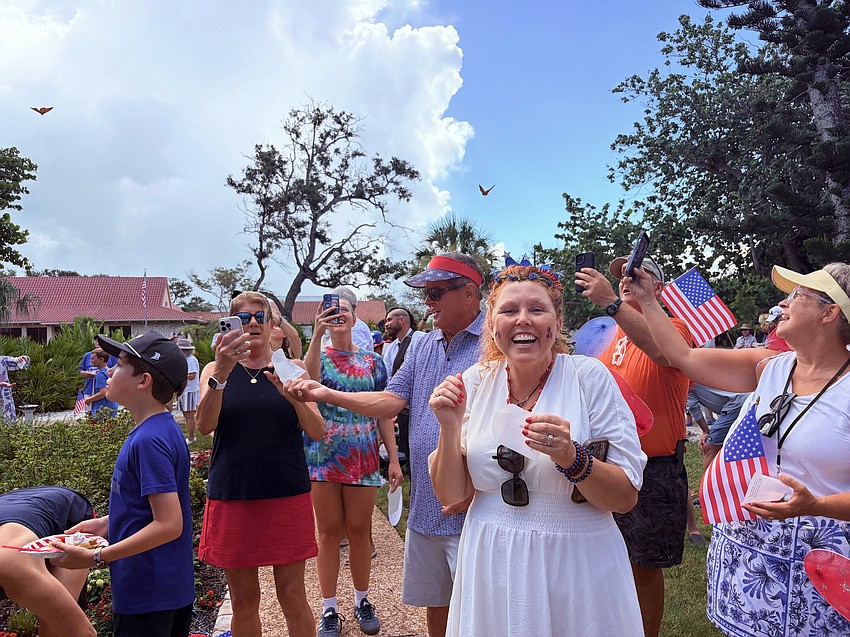 Tryla Brown Larson and other participants in the Freedom Fest butterfly release smile as the winged beauties soar into the clouds.