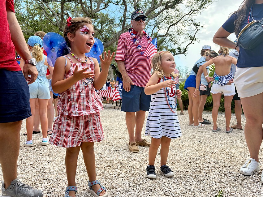 Martina Pickett, 4, and Michelle Ciccero, 3, smile with surprise and delight as the monarch butterfly they were watching on the ground takes flight.