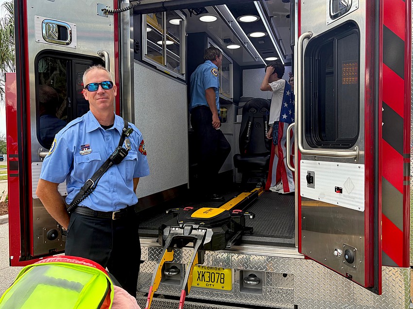 Longboat Key firefighter/paramedic Jay Gosnell gives a final tour of the ambulance at Freedom Fest before closing up to beat the incoming rain.