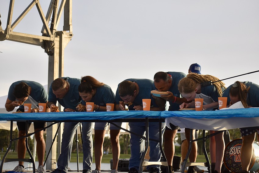 Contestants in the apple pie eating contest dig in.
