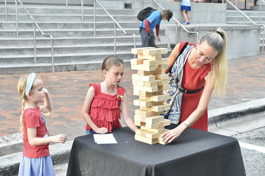 Avel'yn Meyta, 5, Stephanie Meyta, 8 and their mother Inessa Meyta play Jenga.