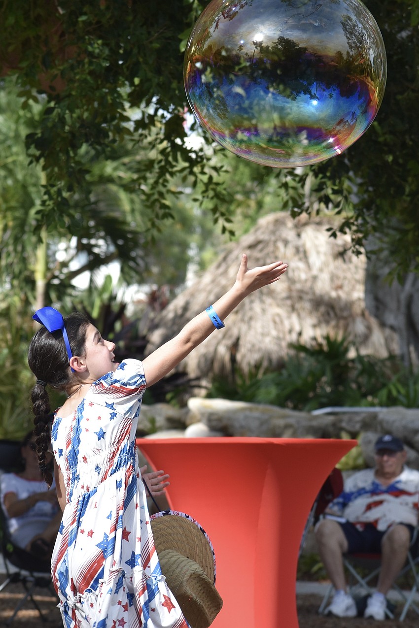 Annalise McLaughlin, 7, reaches high for a bubble.