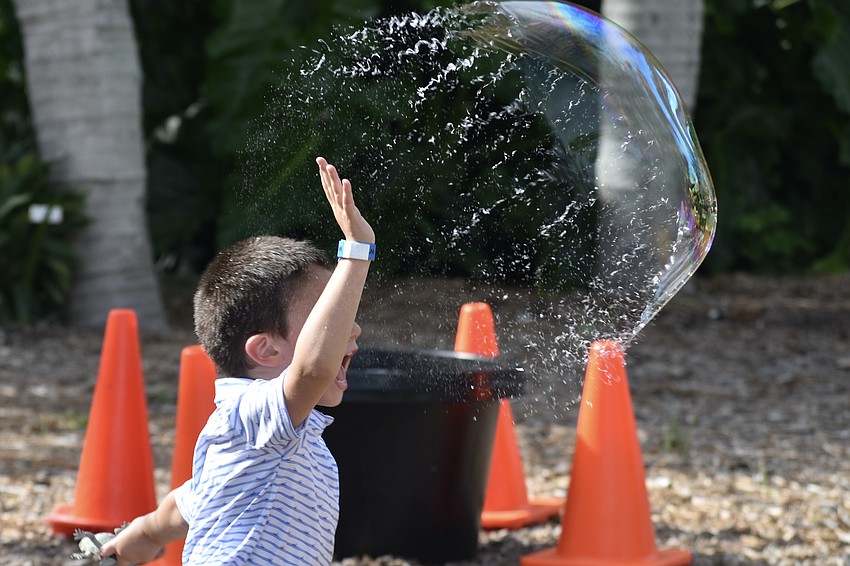 Brooks Keenan, 3, bursts a large bubble.