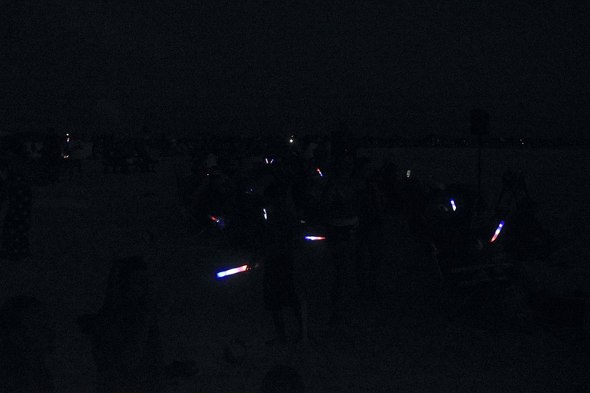 Attendees wave their glow wands as they prepare to watch the fireworks.