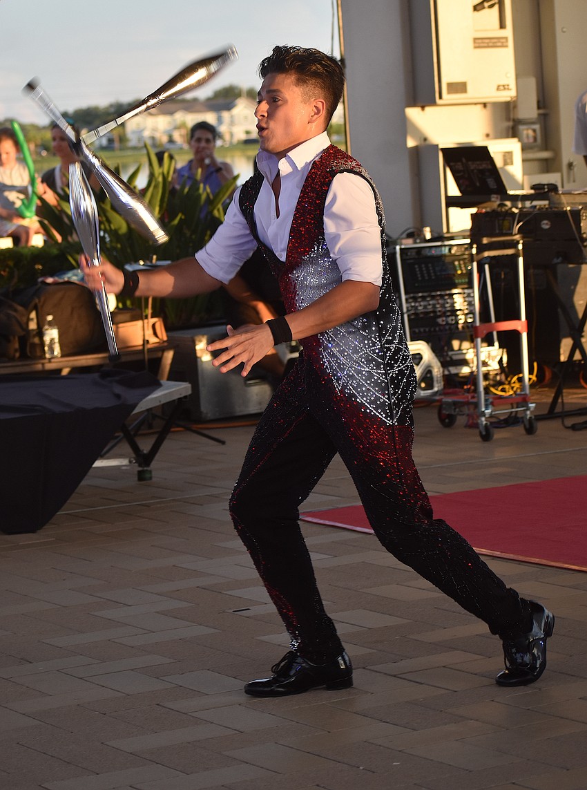 Noel Aguilar, a juggler born into multigenerational circus family, juggles for guests of the Star-Spangled Spectacular at Waterside Place as part of the Circus Acts Conservatory performance.