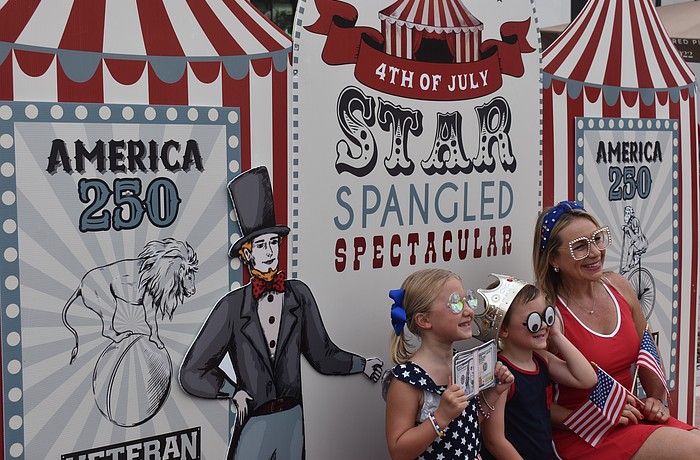 Lakewood Ranch's Harper Fraser, 7, Jack Fraser, 5, and their mom, Melissa Fraser, test out the Royally Cosmic photo booth at the Star-Spangled Spectacular at Waterside Place.