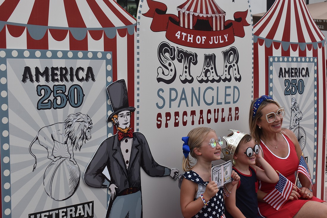 Lakewood Ranch's Harper Fraser, 7, Jack Fraser, 5, and their mom, Melissa Fraser, test out the Royally Cosmic photo booth at the Star-Spangled Spectacular at Waterside Place.