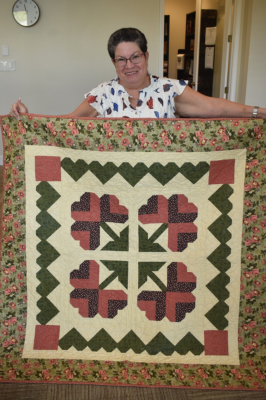Star Farms’ Rosemary Cummings shows off a red and green quilt she started in 1993. It is one of the projects that she spent years waiting to finish.
