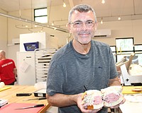 Jason Starkman, the director of operations for The Original Wolfie's and Rascal House restaurants, shows off a corned beef sandwich. Wolfie's 21 Hand Cut is coming to UTC in late November or early December.