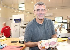 Jason Starkman, the director of operations for The Original Wolfie's and Rascal House restaurants, shows off a corned beef sandwich. Wolfie's 21 Hand Cut is coming to UTC in late November or early December.