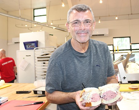 Jason Starkman, the director of operations for The Original Wolfie's and Rascal House restaurants, shows off a corned beef sandwich. Wolfie's 21 Hand Cut is coming to UTC in late November or early December.