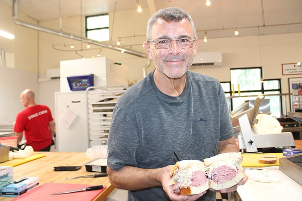 Jason Starkman, the director of operations for The Original Wolfie's and Rascal House restaurants, shows off a corned beef sandwich. Wolfie's 21 Hand Cut is coming to UTC in late November or early December.