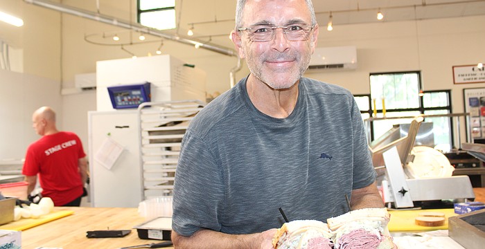 Jason Starkman, the director of operations for The Original Wolfie's and Rascal House restaurants, shows off a corned beef sandwich. Wolfie's 21 Hand Cut is coming to UTC in late November or early December.