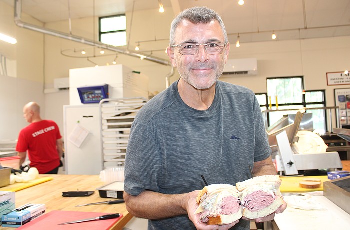 Jason Starkman, the director of operations for The Original Wolfie's and Rascal House restaurants, shows off a corned beef sandwich. Wolfie's 21 Hand Cut is coming to UTC in late November or early December.