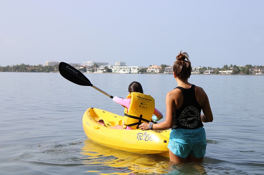 Amaia Del Mar Meja paddles through the Sarasota Bay with help from Camp Educator Morgan Swartz.