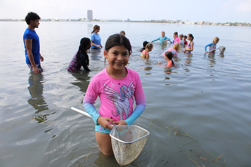 Camper Amaia Del Mar Meja shows off her findings while dip netting at the Mote City Island Adventure Camp.