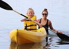 Poppy Otte paddling through the water while Mote Education Specialist Morgan Swartz helps.