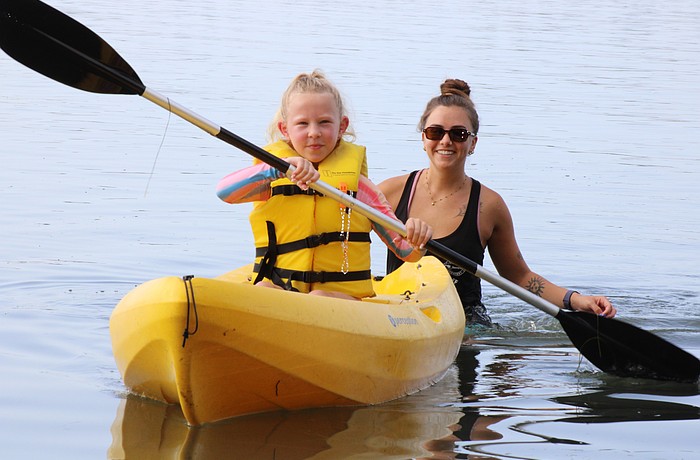 Poppy Otte paddles through the water while Mote Education Specialist Morgan Swartz helps.